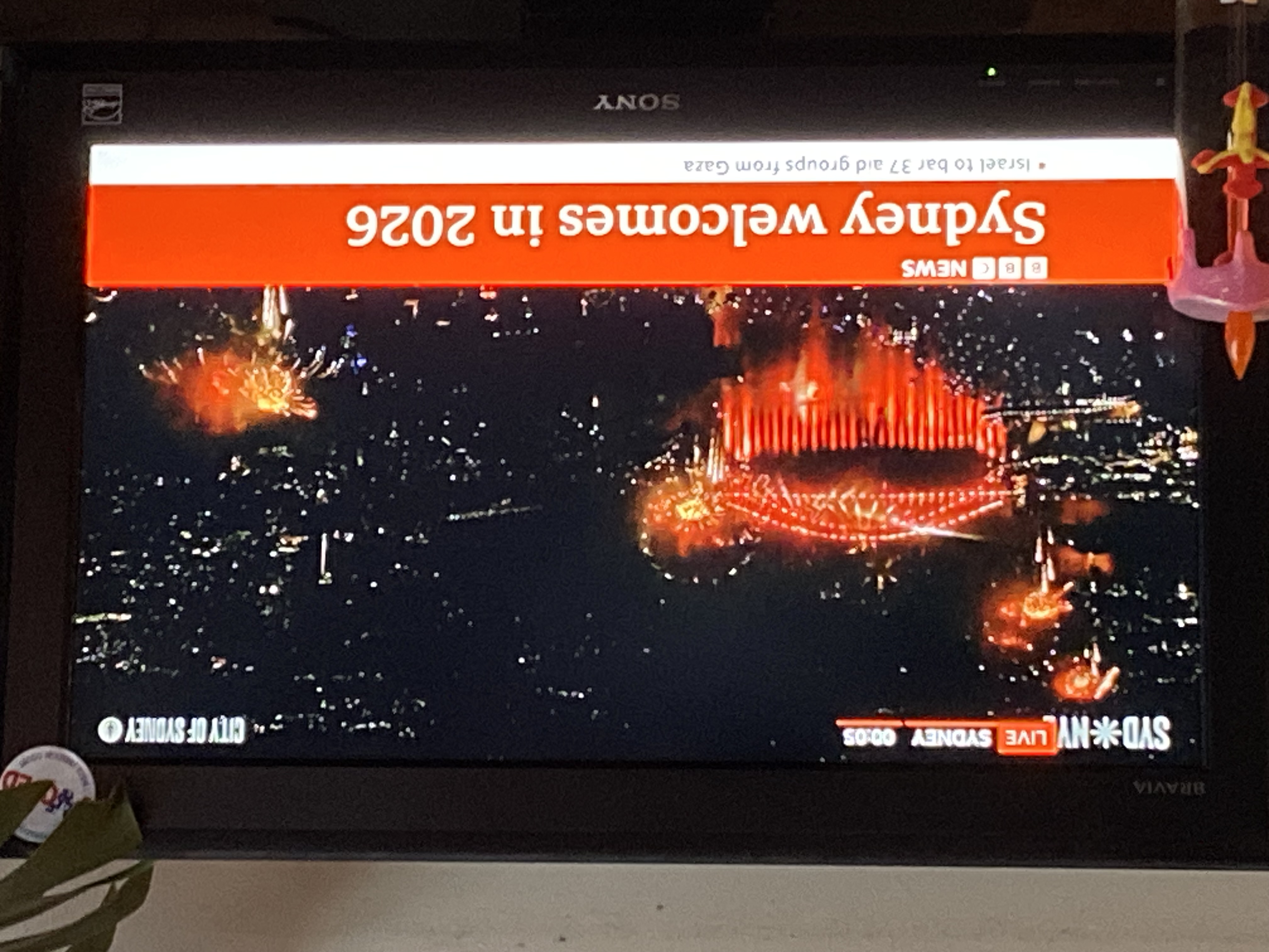 TV screen showing fireworks in Sydney for New Year's, ringing in 2026